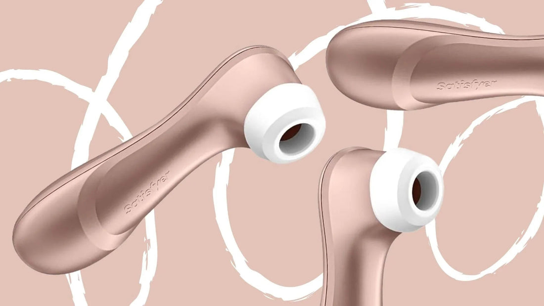 Rose gold softsyster personal massagers with white silicone tips on a beige background