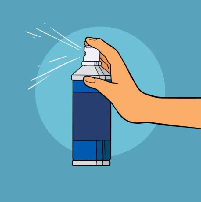 Hand spraying blue aftershave spray bottle with white nozzle on blue background