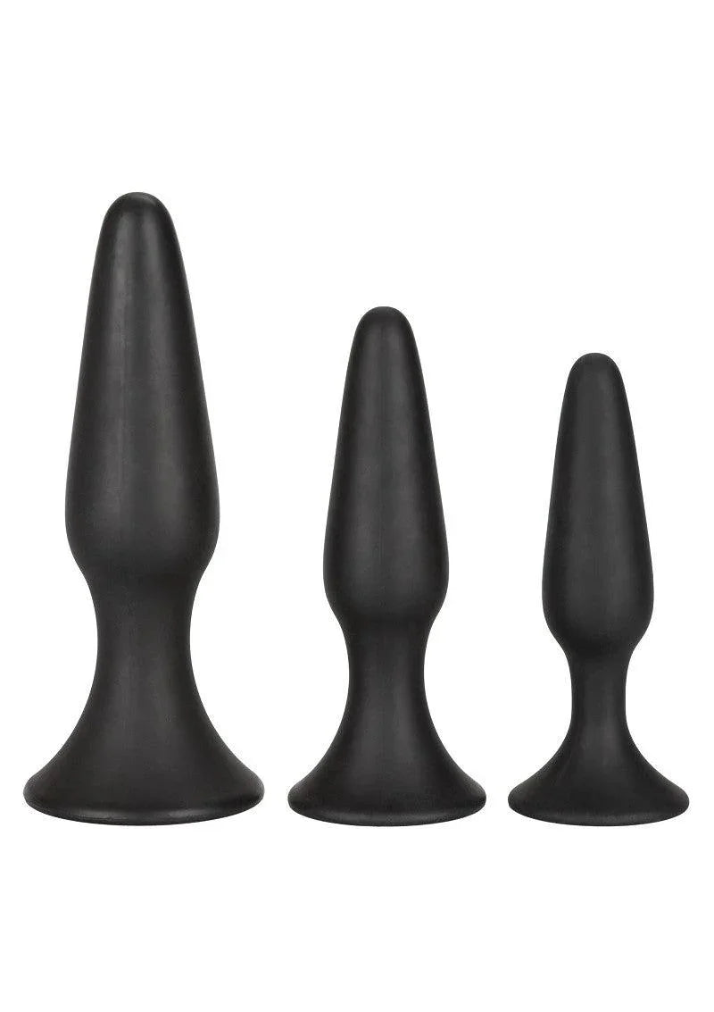 Set of three black silicone anal trainer plugs in varying sizes with flared bases on white background